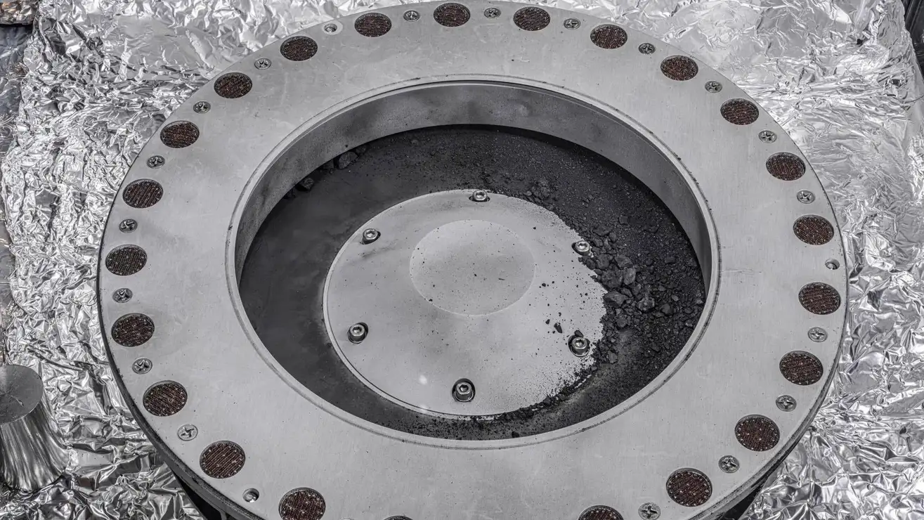 Detritos do asteróide Bennu na parte externa do coletor de amostras OSIRIS-REx.