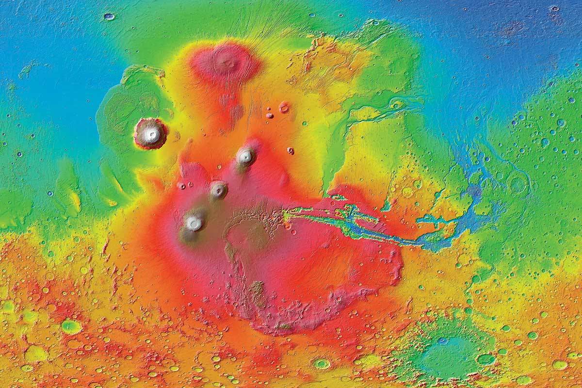 Esta imagem colorida da superfície de Marte foi criada com dados da Mars Reconnaissance Orbiter. A linha de três vulcões é Tharsis Montes, com Olympus Mons a noroeste e Valles Marineris a leste. Arsia Mons é o vulcão mais meridional dos três que compõem Tharsis Montes. (NASA/JPL-Caltech/Universidade Estadual do Arizona)